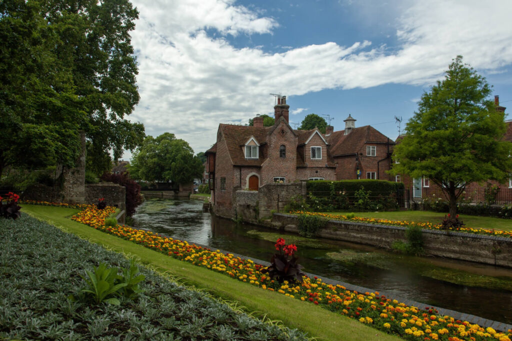 road surrounded by buildings gardens after rain canterbury uk