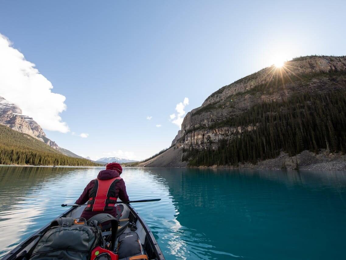 person riding boat in body of water between islands