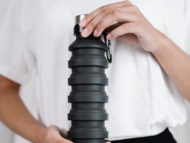 person holding black rubber bottle