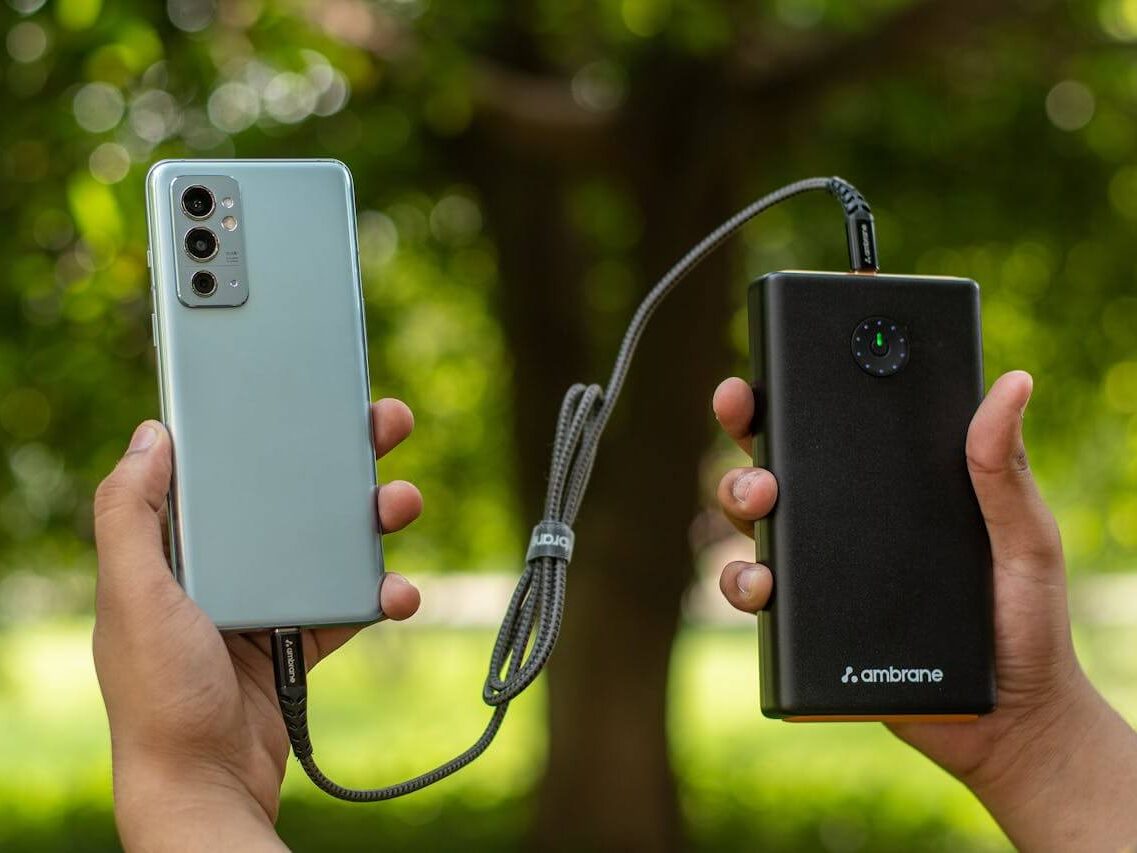 hands holding smartphone and power bank