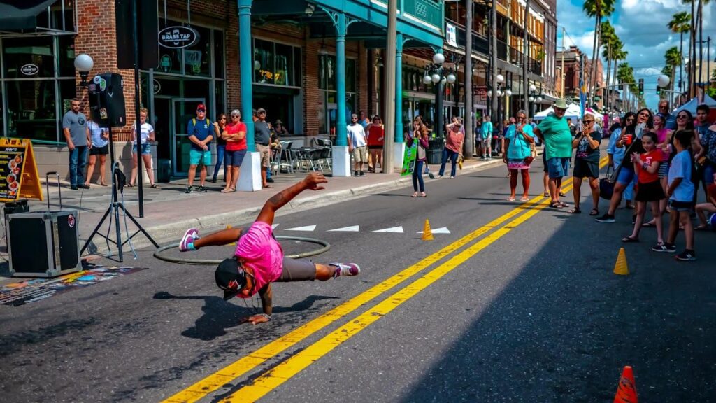 man doing break dancing surrounded with people