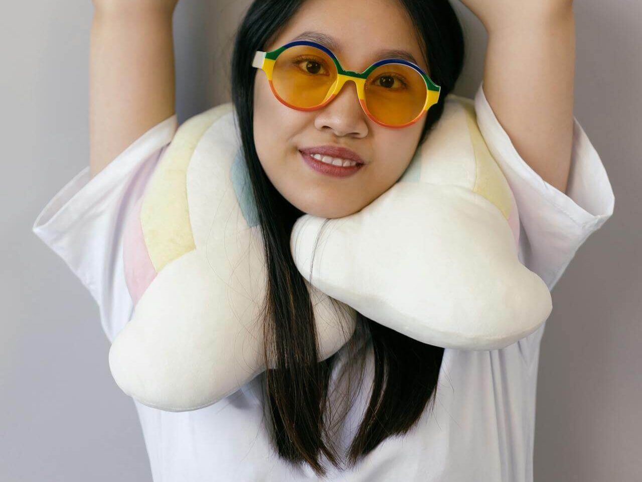 a woman in white shirt wearing colorful sunglasses