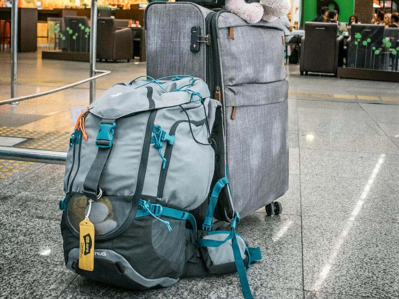 teddy bear sitting a top luggage in airport