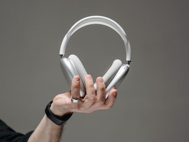 hand holding a white wireless headphones