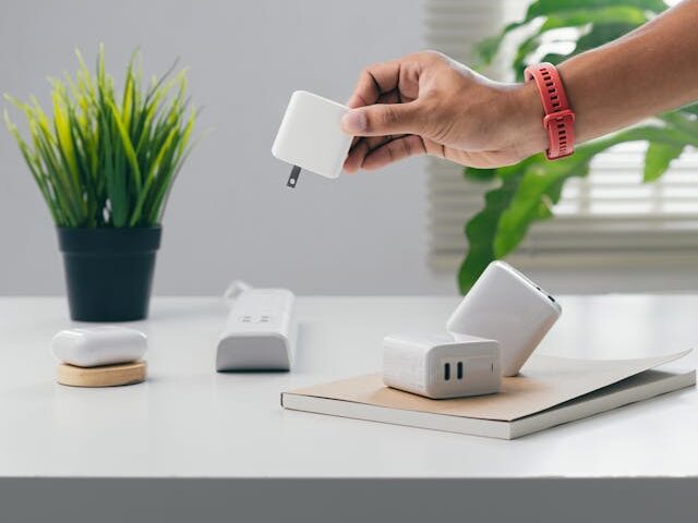 person holding a white power adaptor